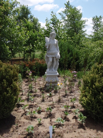 Statue in flower bed