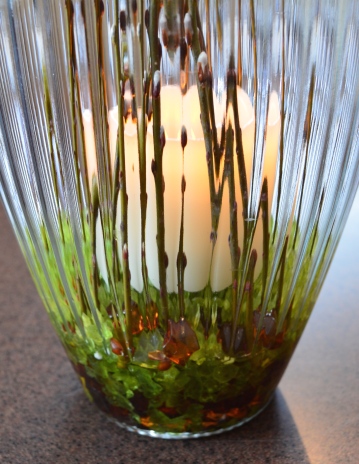 Close up of candle and pussy willows in a vase.
